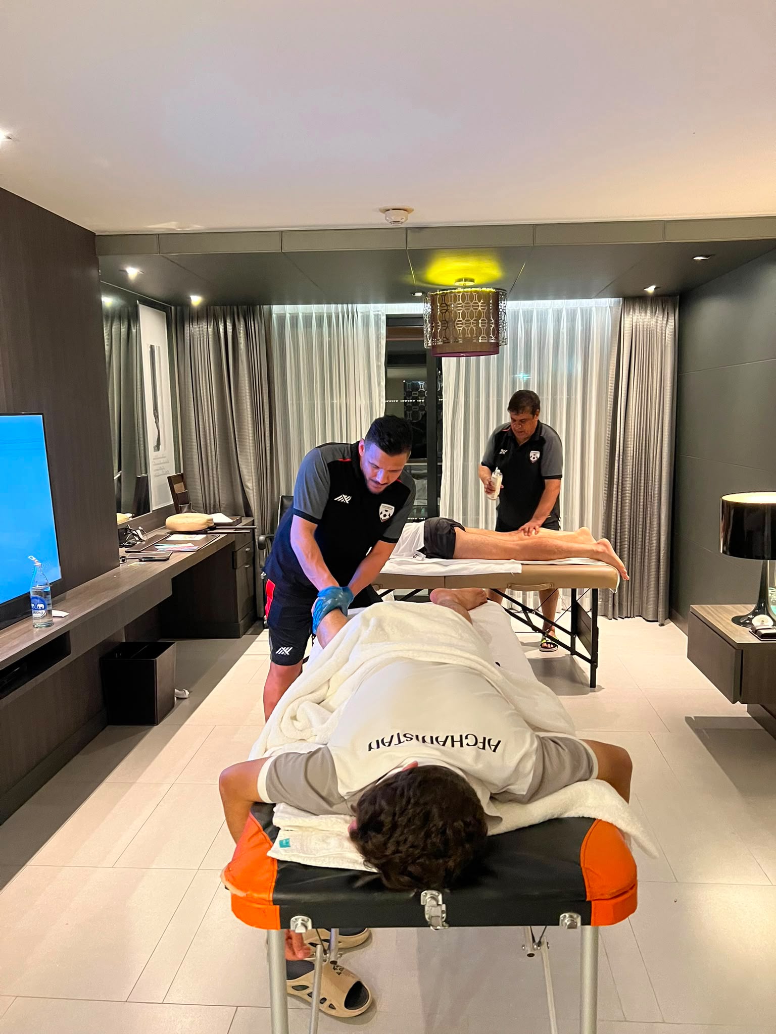 Athletes in Afghanistan robes receiving treatment in a hotel suite