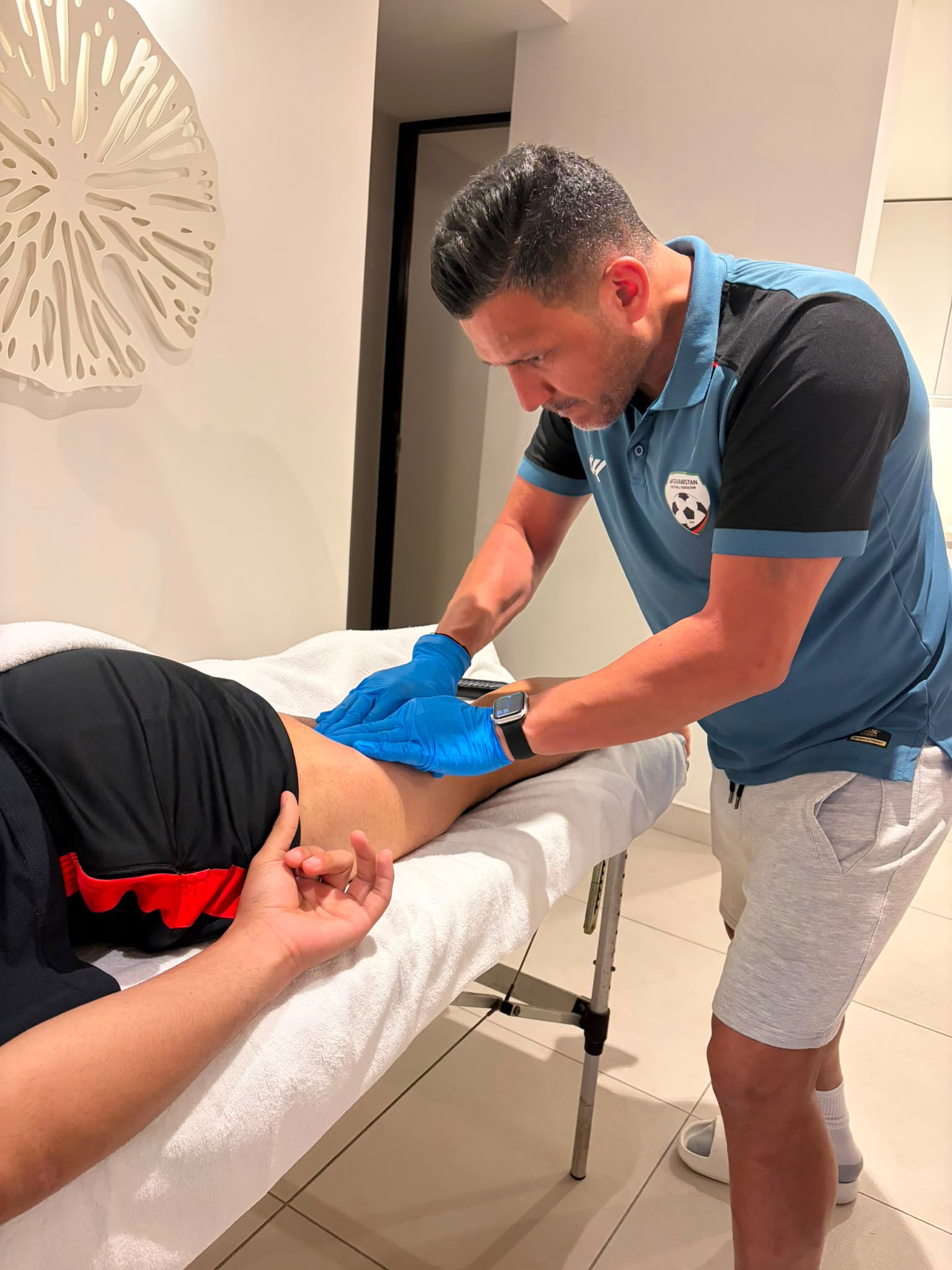 Instrument-assisted soft-tissue treatment on an athlete's leg during a private session