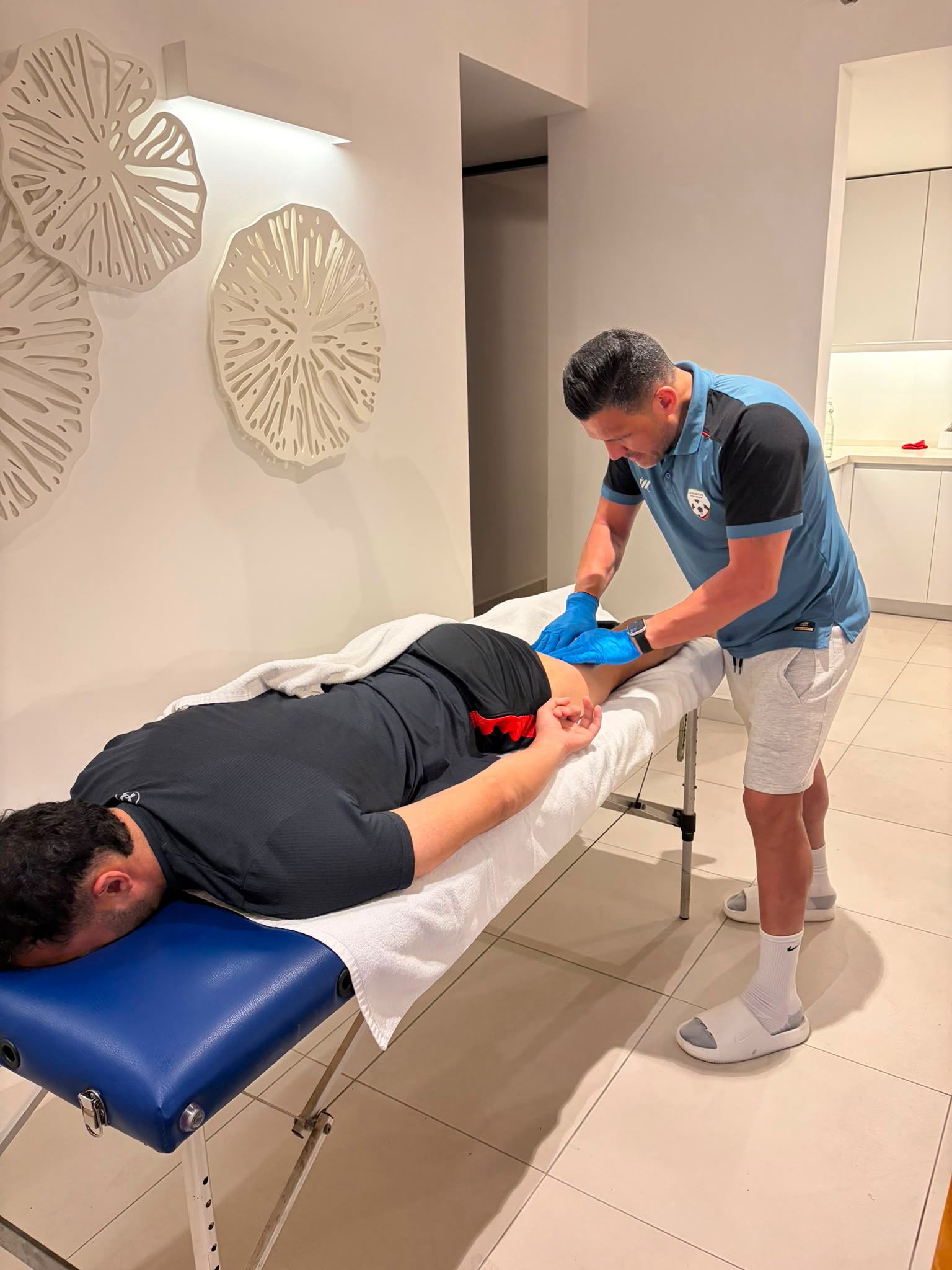 Amir Tamim Sultani working an athlete's calf at a full treatment table